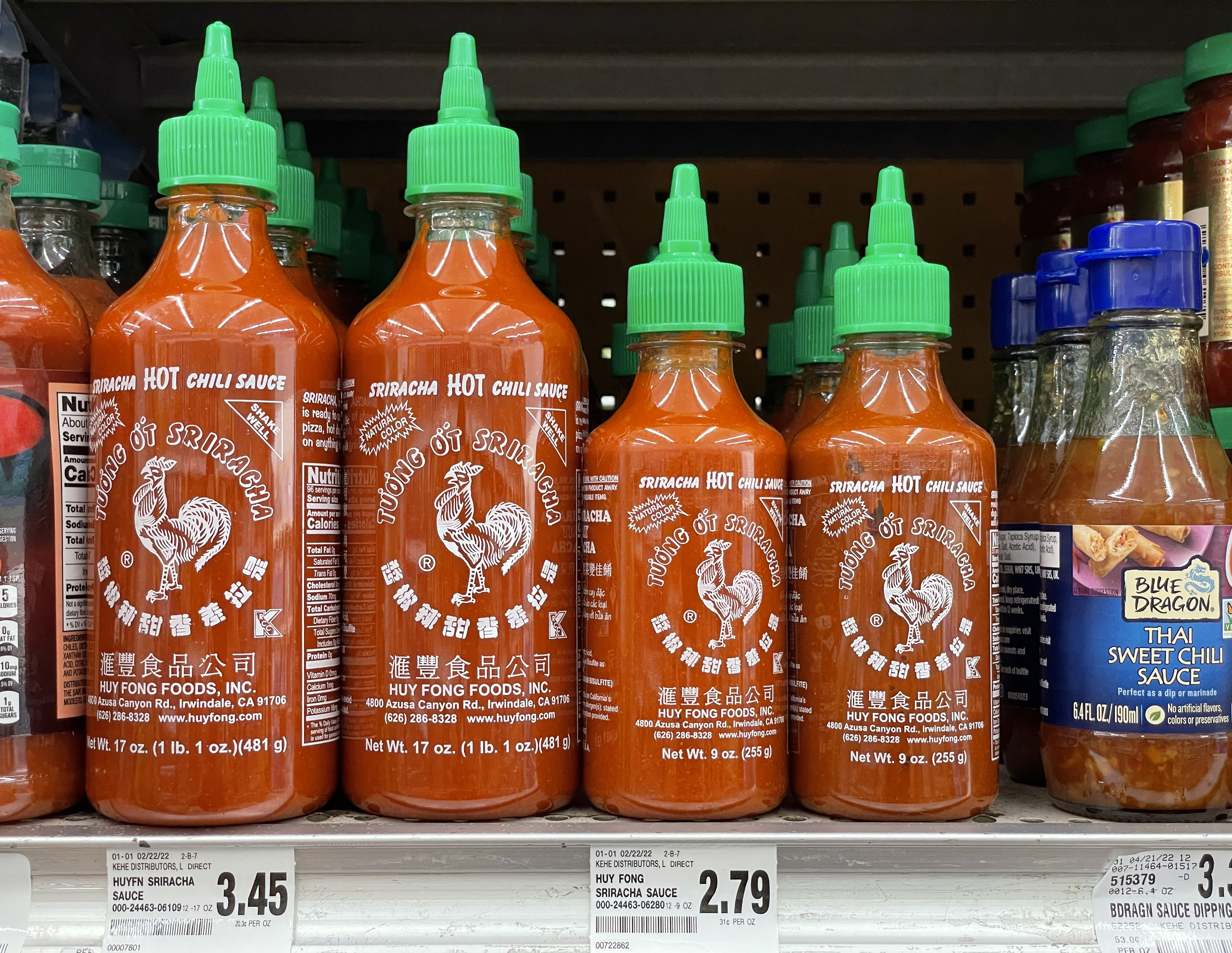 Bottles of sriracha on a grocery store shelf