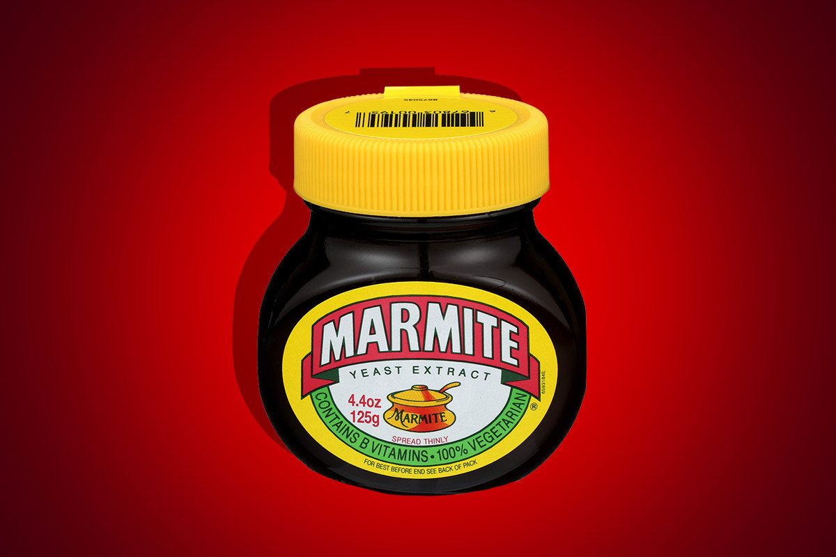 A jar of Marmite against a red backdrop.