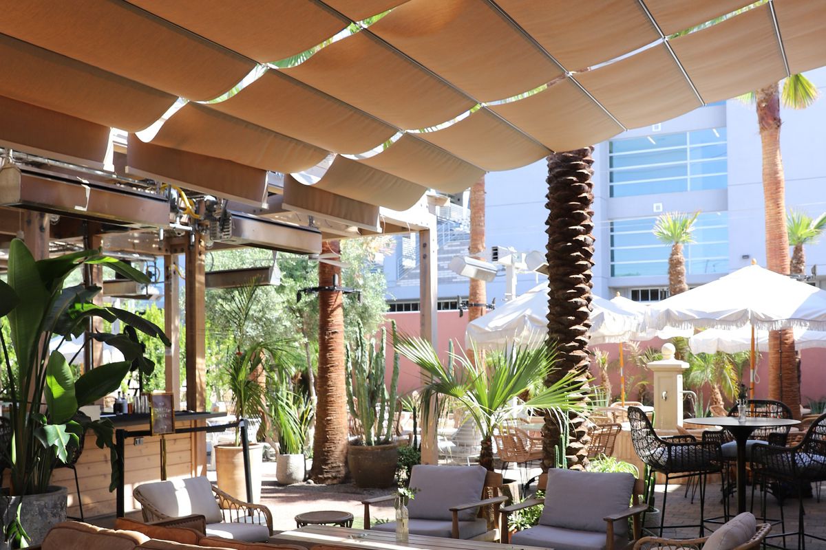 An empty patio with lots of seating and plants. 