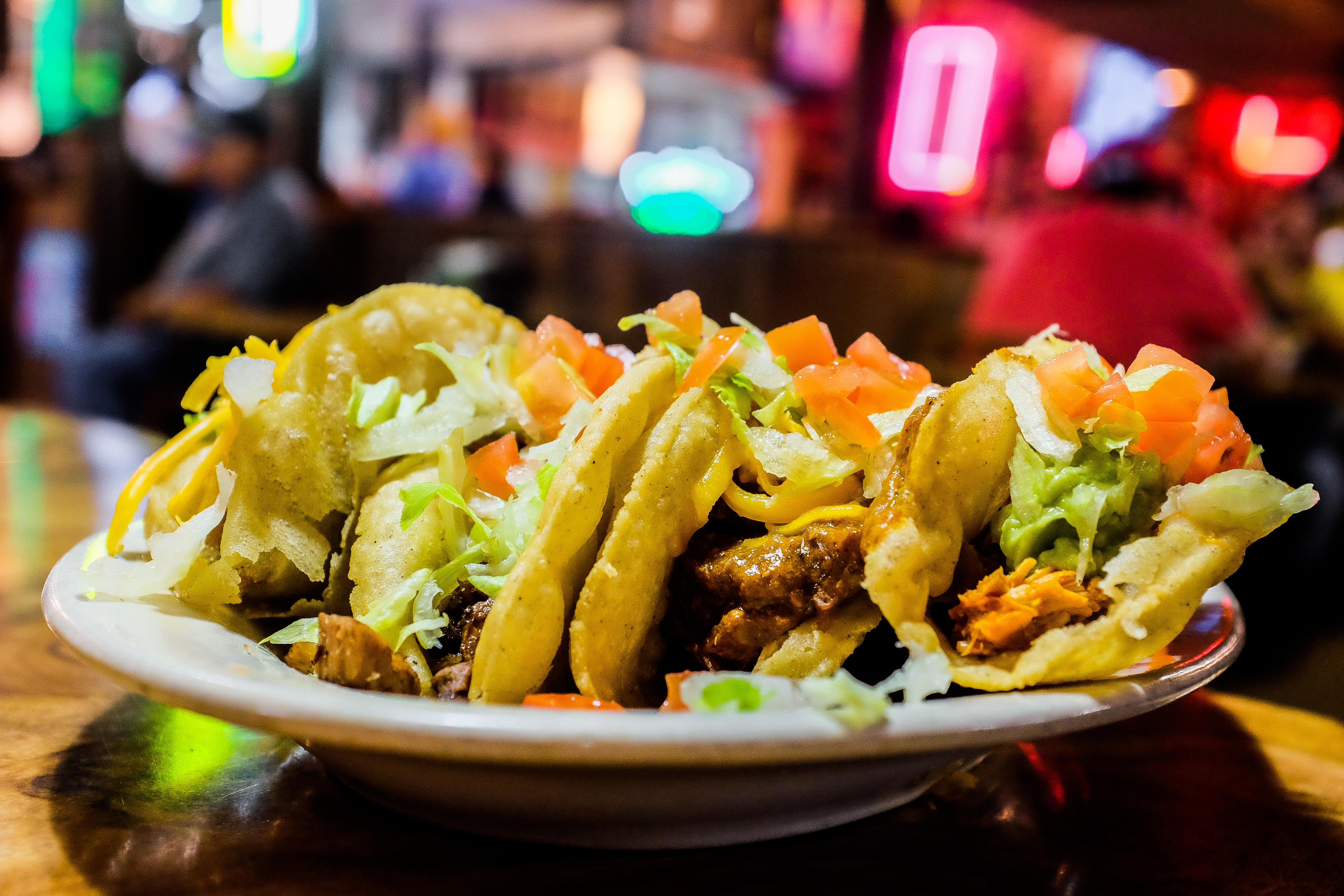 A trio of crispy fried puffy tacos on a platter from Ray’s.