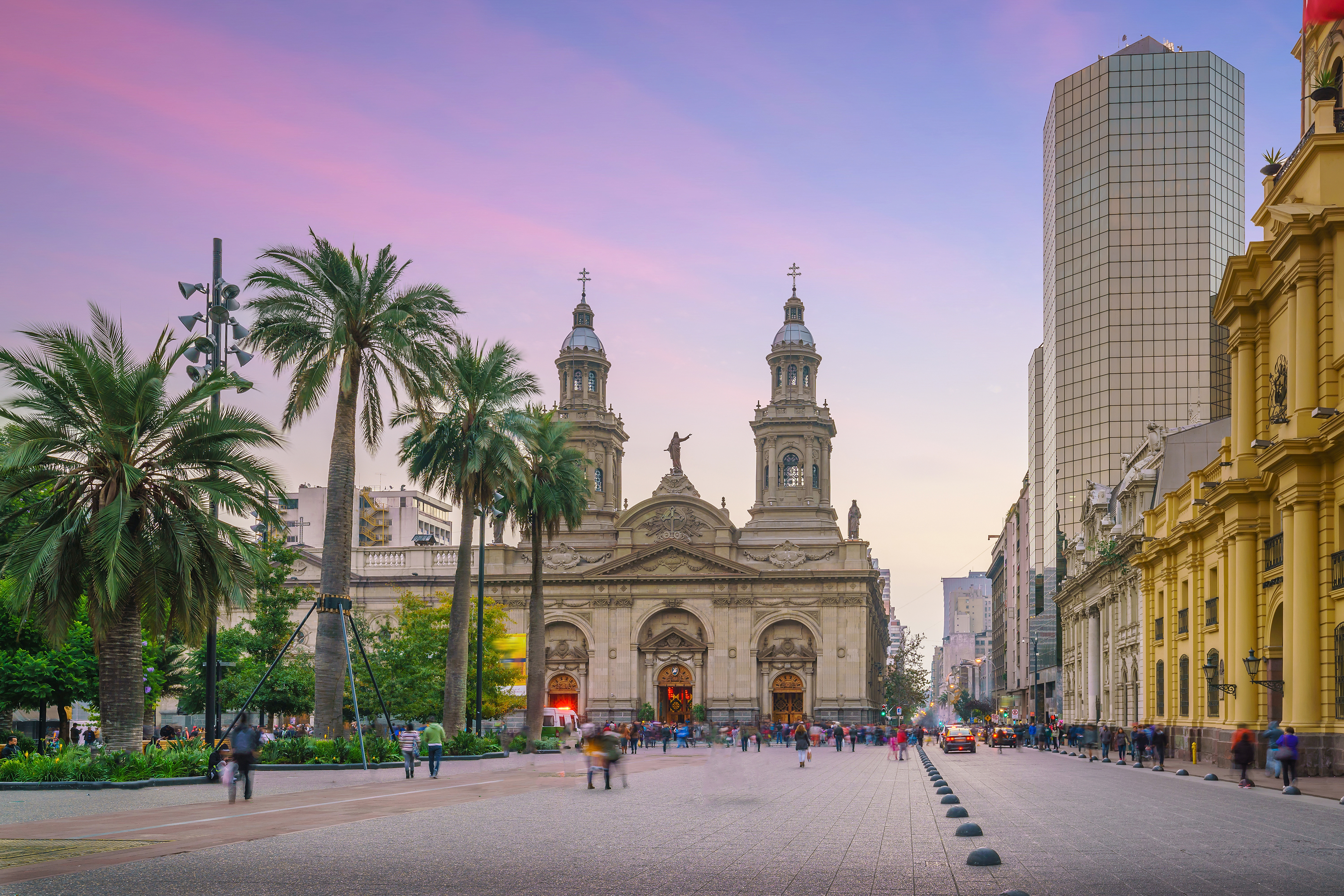 A Spanish-style church in front of a purple sunset.